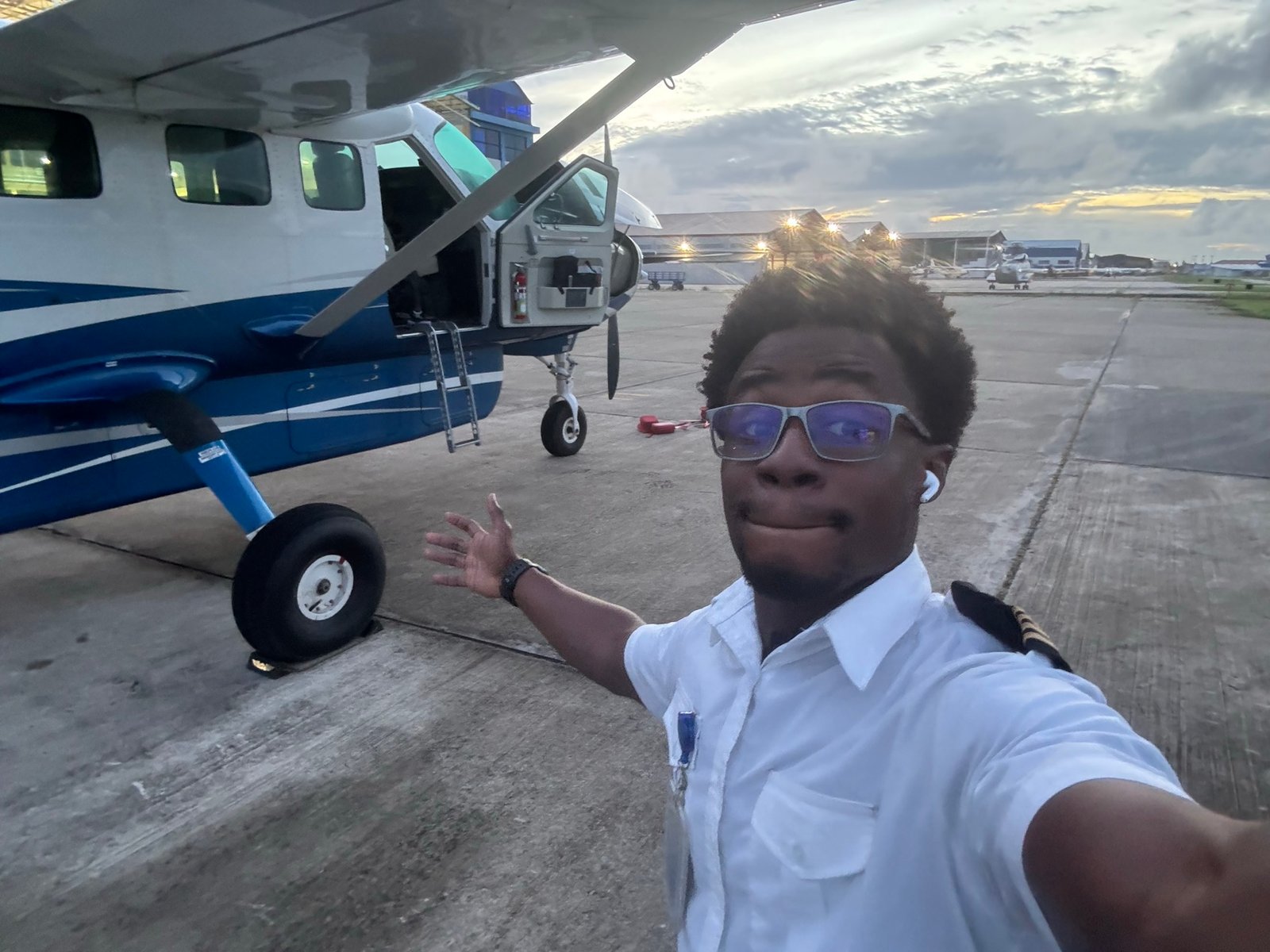 Michael A. Thom in aviation uniform beside a Cessna Caravan, Guyana