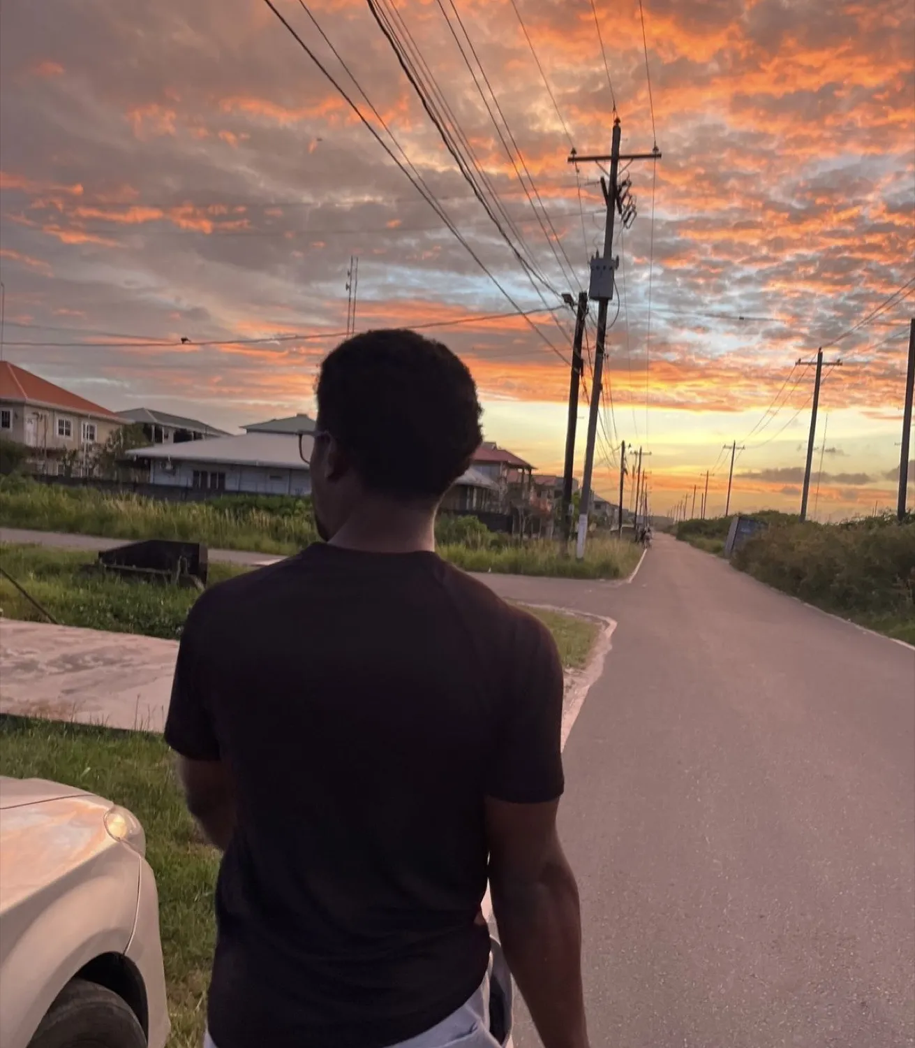 Michael A. Thom walking a Guyana road at sunset