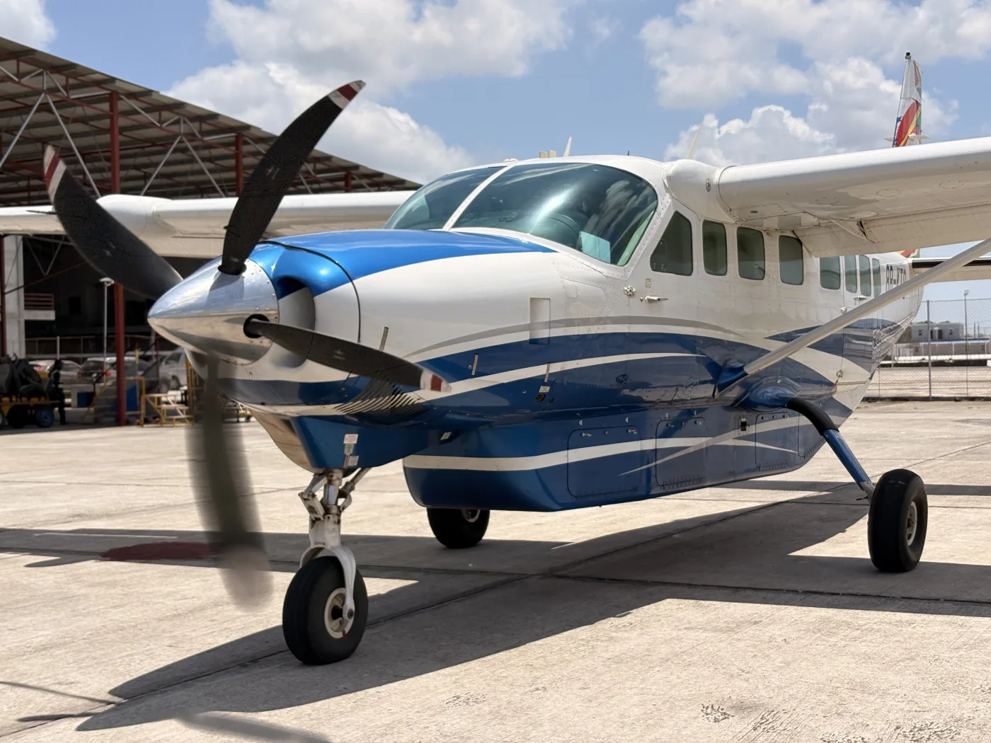 Blue and white Cessna Caravan on the apron in daylight