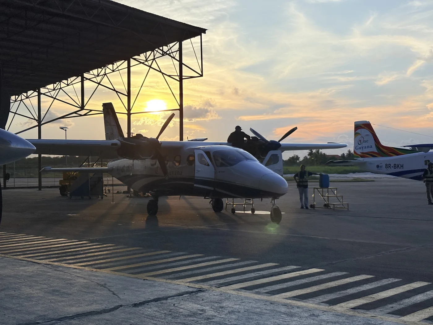 Aircraft maintenance under the hangar roof at sunset